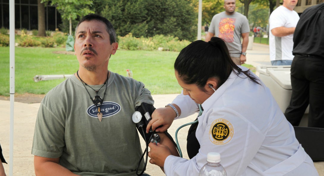 College of Nursing student taking blood pressure at a community event