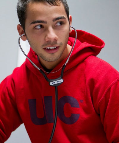 male student practicing with stethoscope