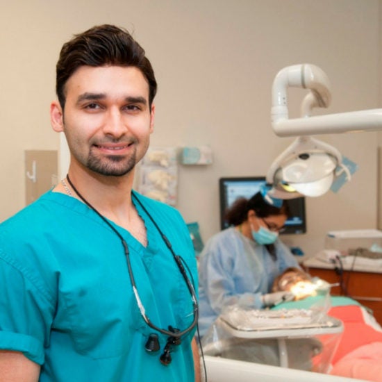 dental student facing camera with practice dental exam in the background 