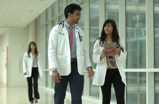 male and female medical students walking down a hallway